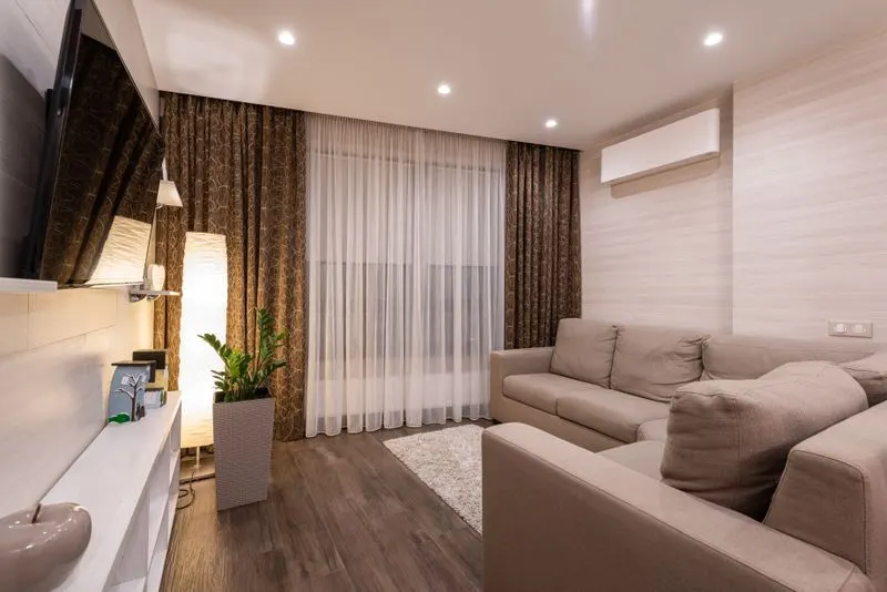 Warmly lit living room with a wall-mounted mini-split unit