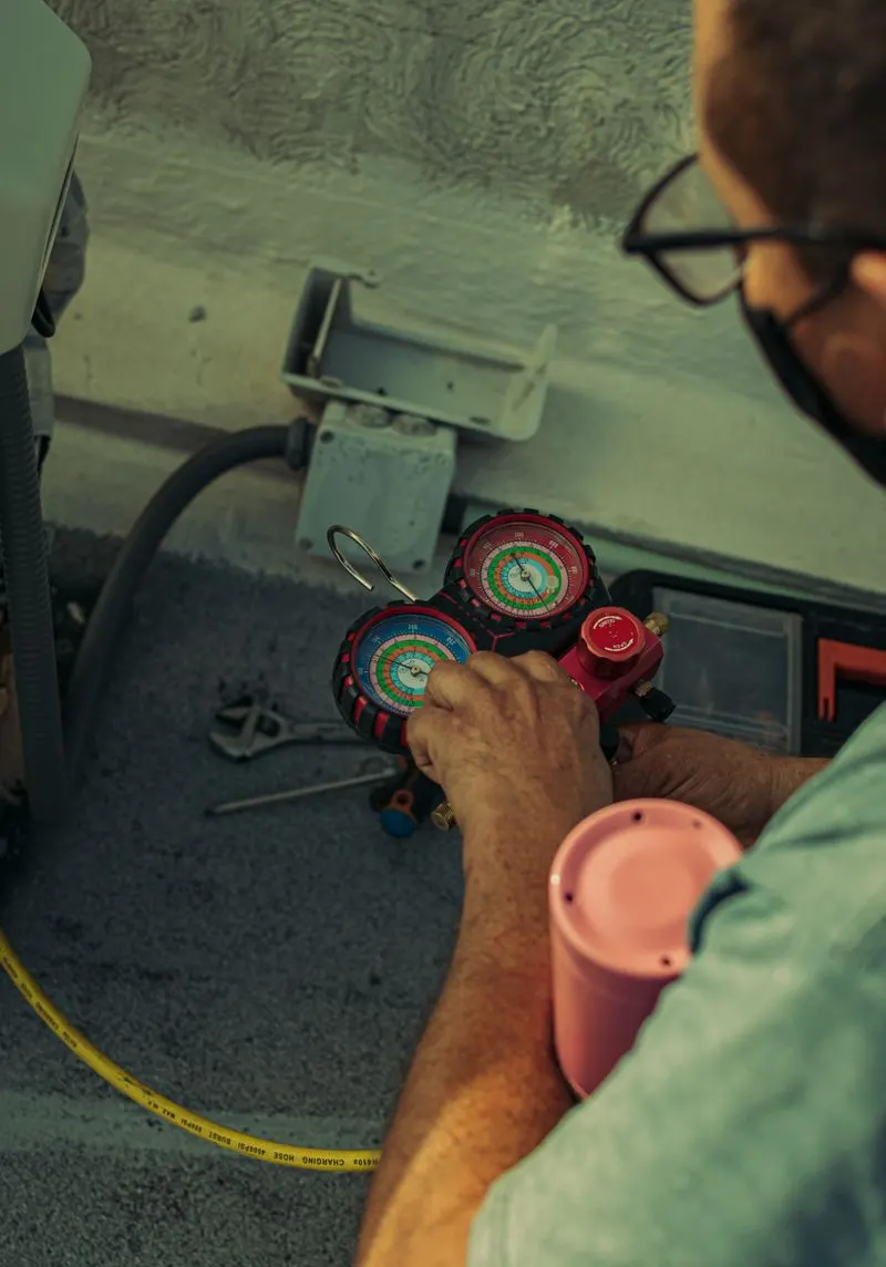 Close-up of a technician reading refrigerant manifold gauges