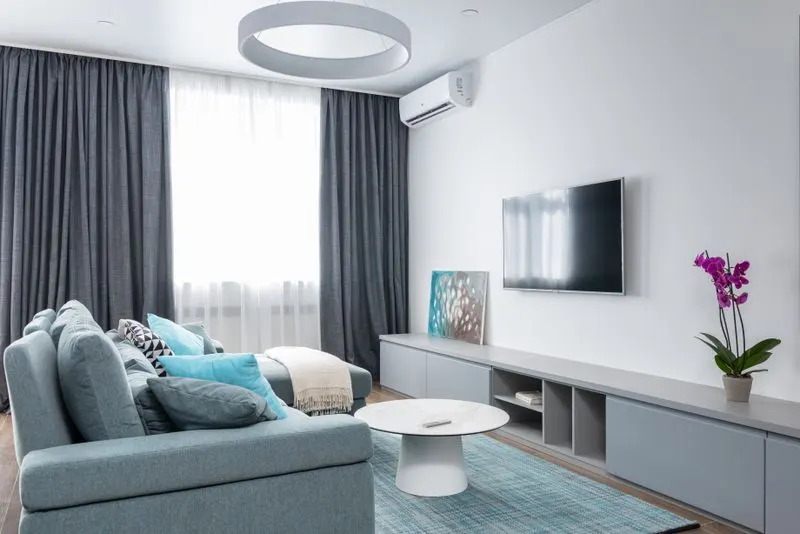 Living room with a wall-mounted ductless mini-split unit above the television
